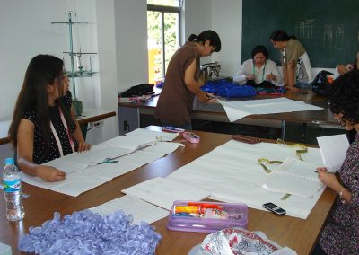 Alumnas en la case de patronaje, corte y confección elaborando patrones.