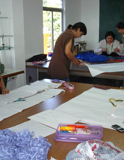 Alumnas en la case de patronaje, corte y confección elaborando patrones.