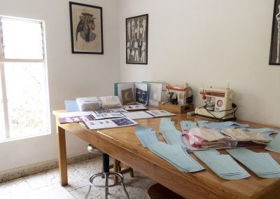 Salón multi usos de las instalaciones de Escuela de Diseño y Modas Gama. Se muestra en una mesa distintos proyectos de los alumnos.